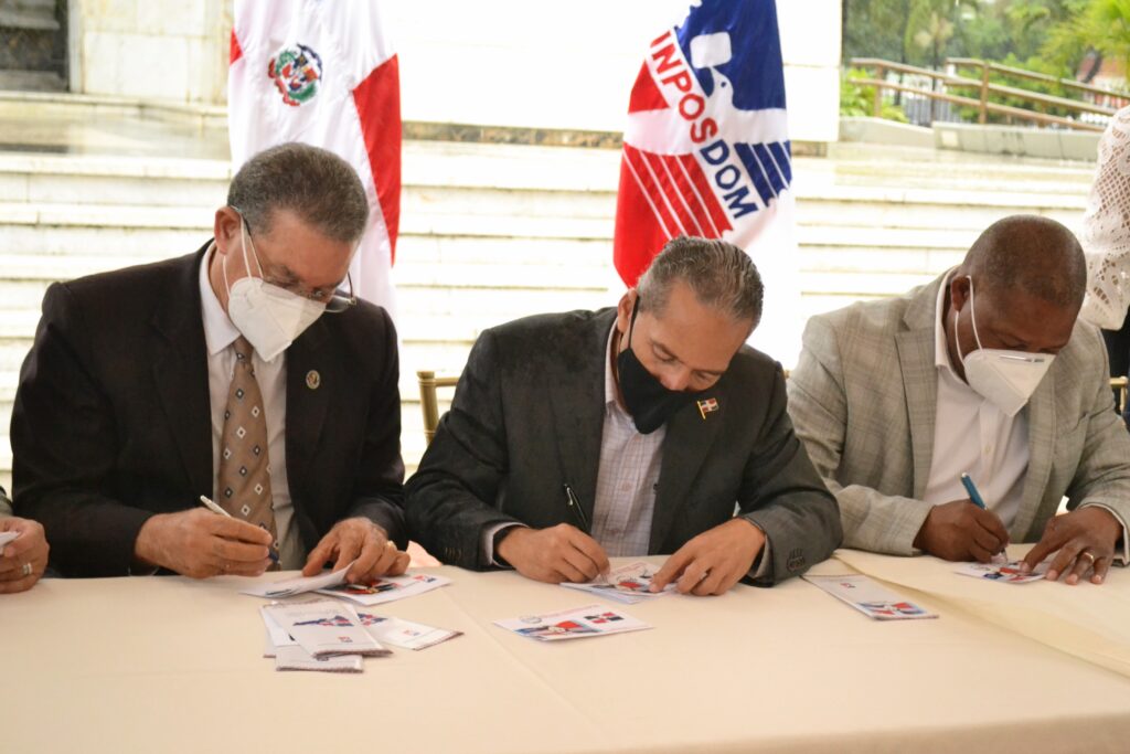 Wilson Gómez, Juan Pablo Uribe y Adán Peguero, mientras firman la nueva emisión postal.